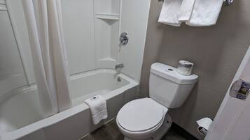 Een badkamer met een bad, toilet en een handdoekhouder.