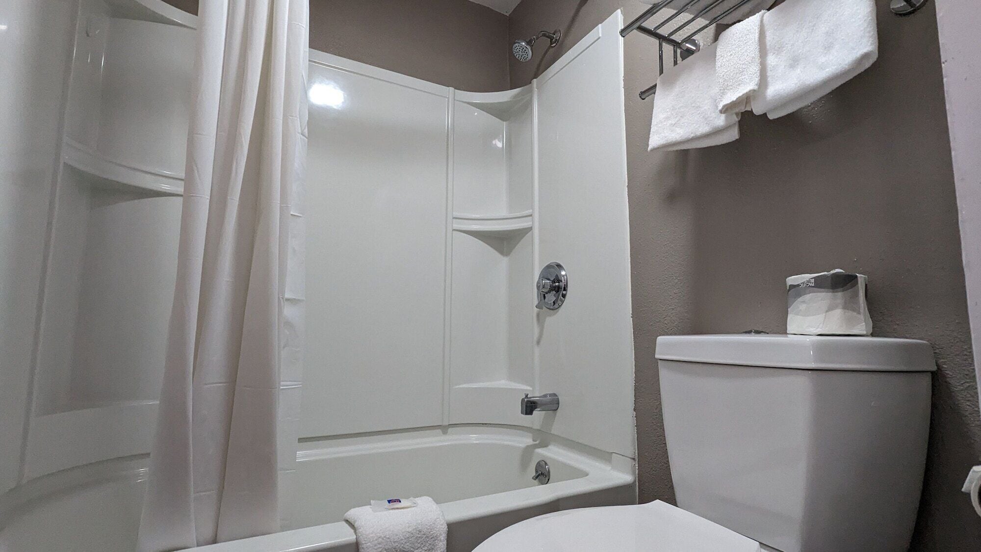 Ein Badezimmer mit Dusche, Toilette und Handtuchhalter.