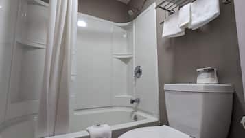 Ein Badezimmer mit Dusche, Toilette und Handtuchhalter.
