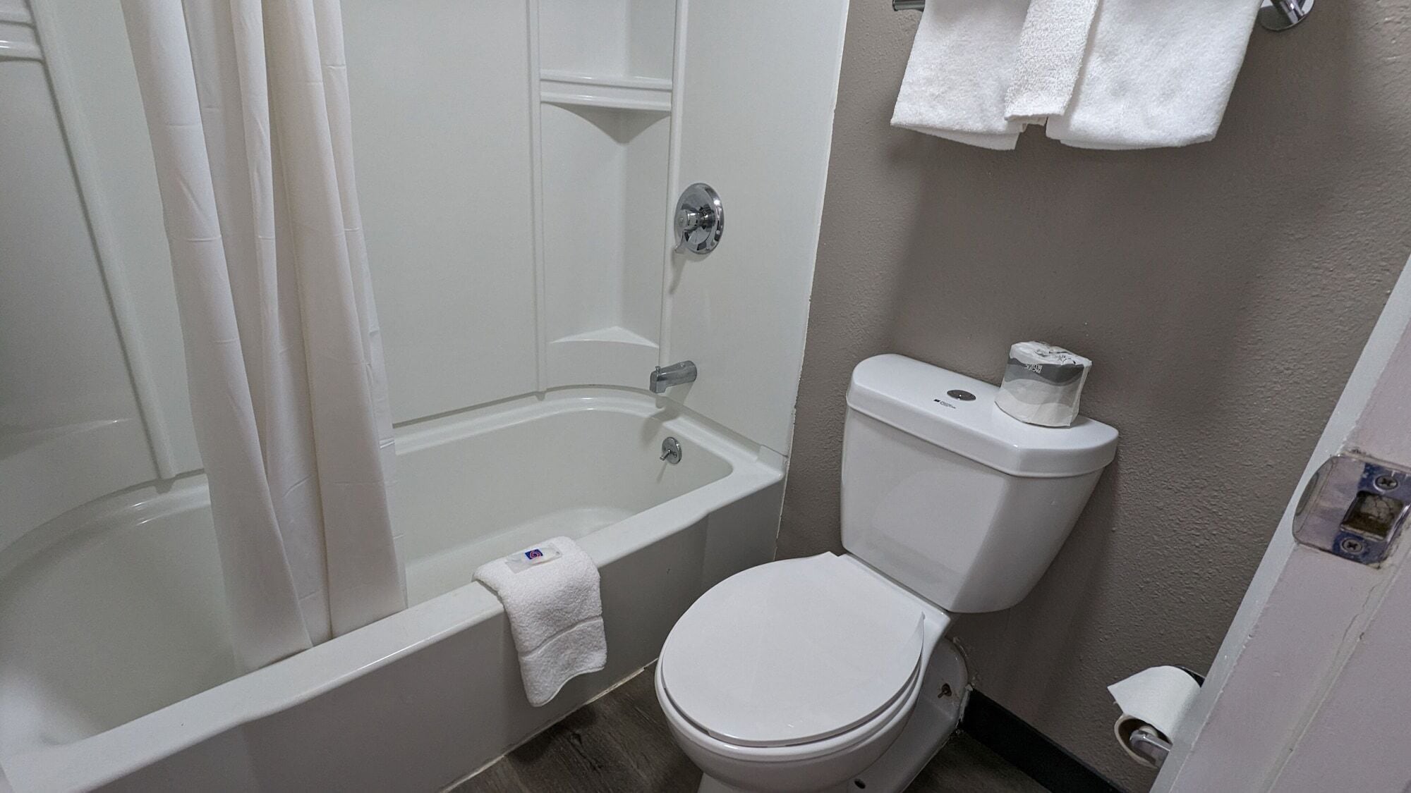 A bathroom with a bathtub, toilet, and a towel rack.