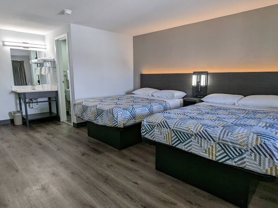 Habitación de hotel con dos camas, baño y escritorio.