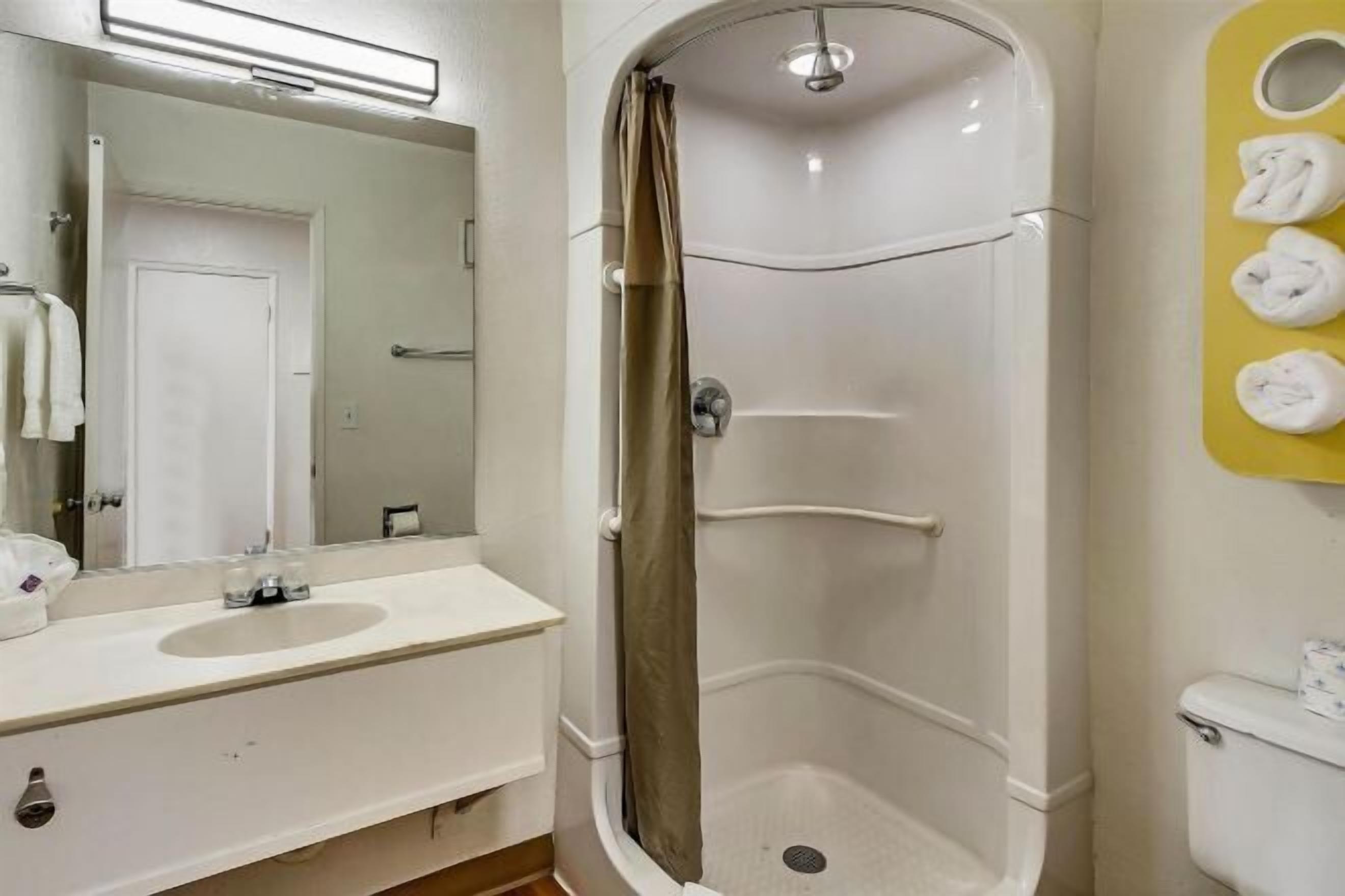 Een bad/douchecombinatie, handdoeken