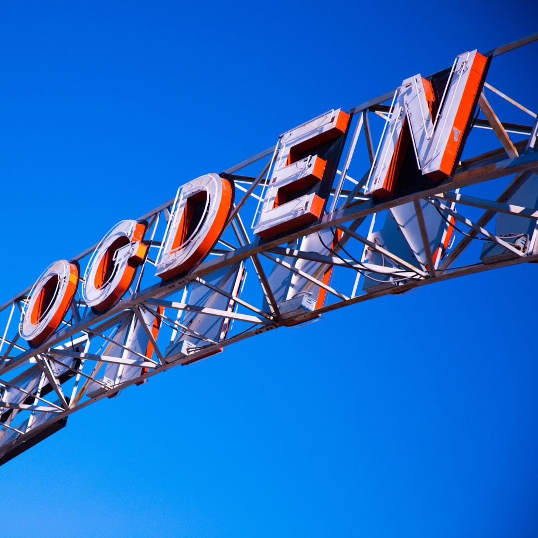 A metal structure with the word "OGDEN" prominently displayed against a clear blue sky.