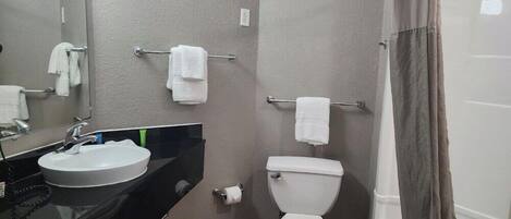 Een badkamer met een wastafel, toilet en handdoekrek.