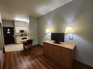 A compact hotel room with a kitchenette, a dining area, and a TV on a dresser. - Motel 6 Biloxi, MS - Beach (Biloxi)