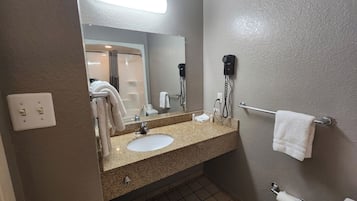 A bathroom with a sink, mirror, towel rack, and hairdryer.