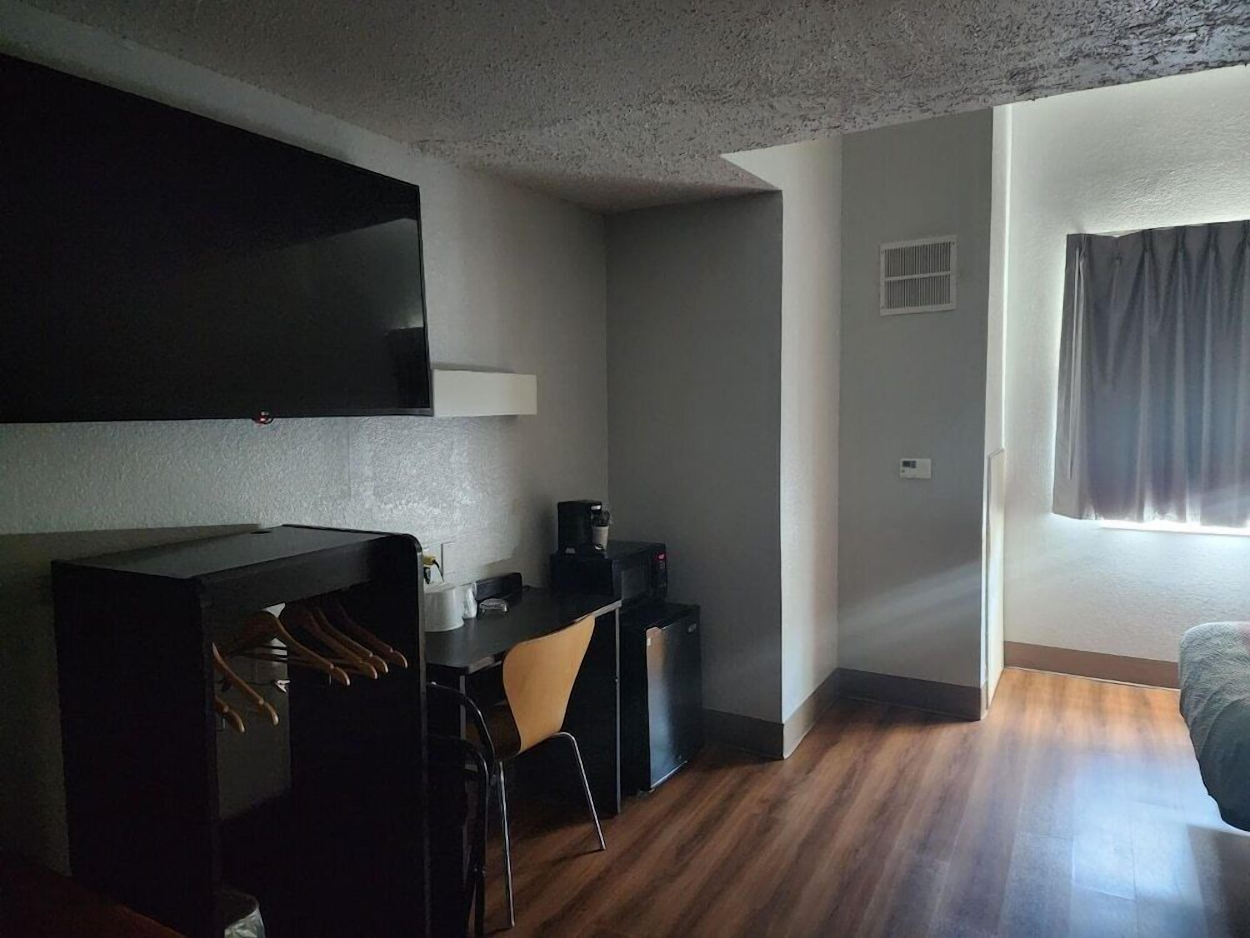 Un espacio habitable compacto con kitchenette, comedor y cama.