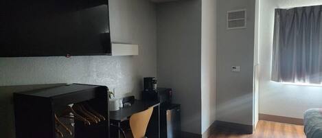 Un espacio habitable compacto con kitchenette, comedor y cama.