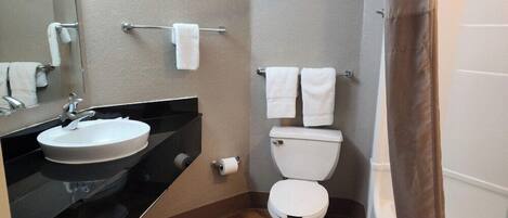 A bathroom with a sink, toilet, and a shower curtain.