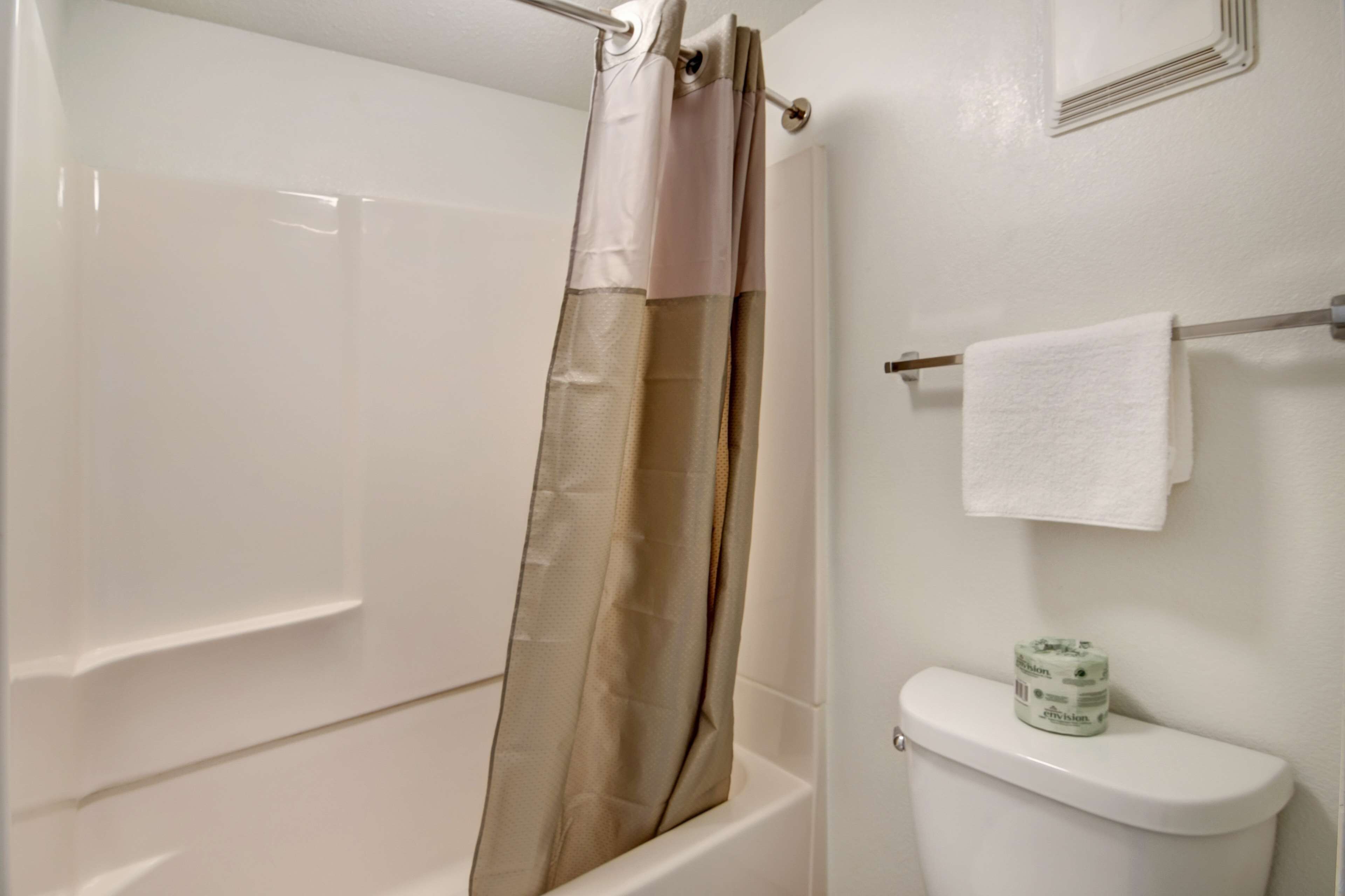 A bathroom with a bathtub, toilet, and a towel rack.