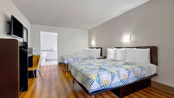 Habitación de hotel con dos camas, un escritorio, una silla, un televisor y una ventana.