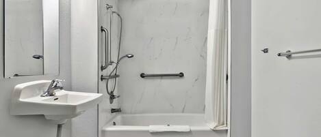 A bathroom with a white sink, a bathtub, and a shower.