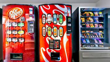 Three beverage vending machines with different brands and drink options.