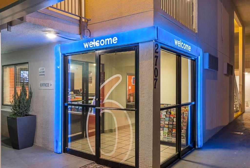 A hotel entrance with a 'Welcome' sign, a visible office sign, and a tiled floor.