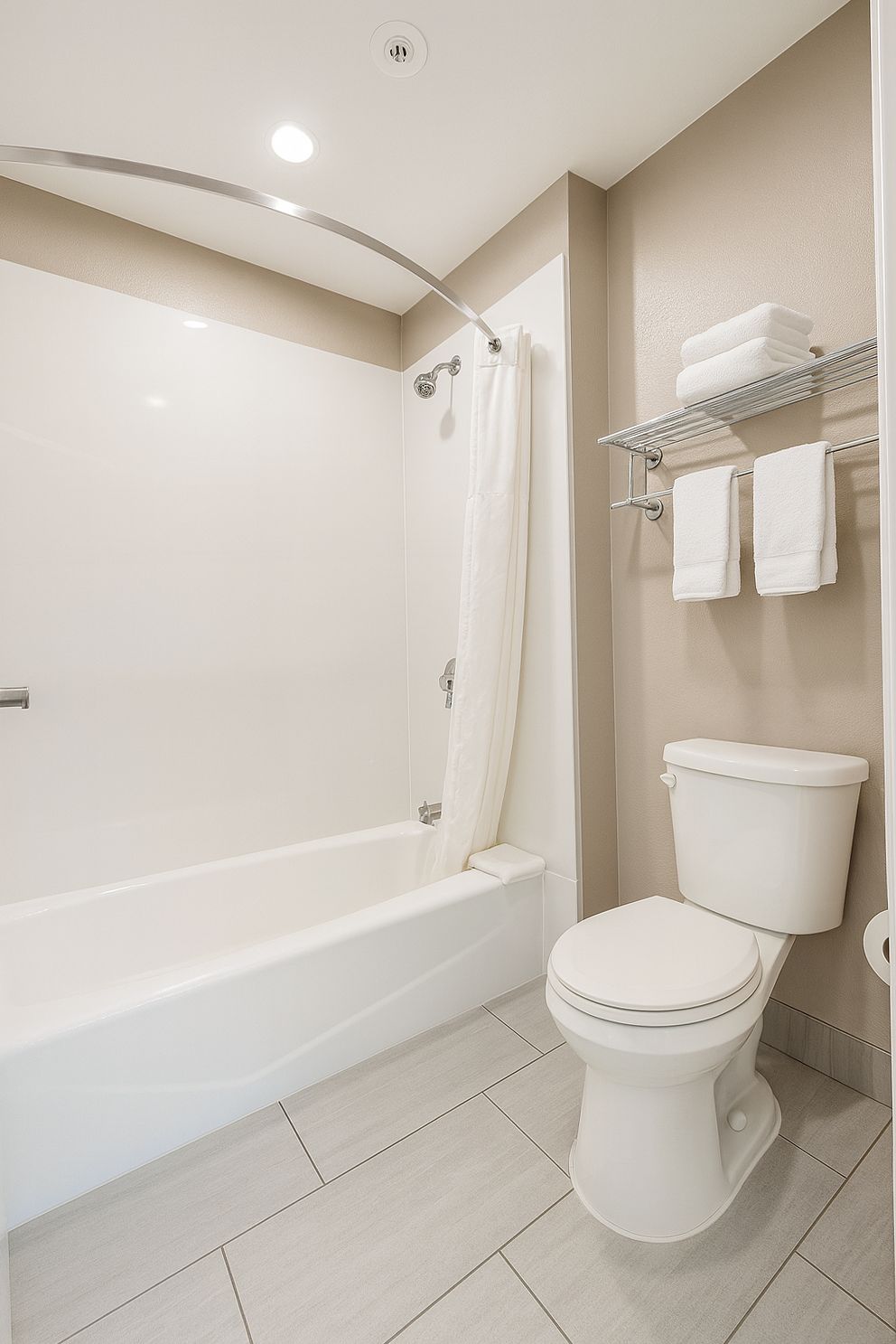 Un baño moderno con bañera, inodoro y un perchero para toallas.