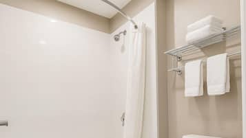 A modern bathroom with a bathtub, toilet, and a towel rack.