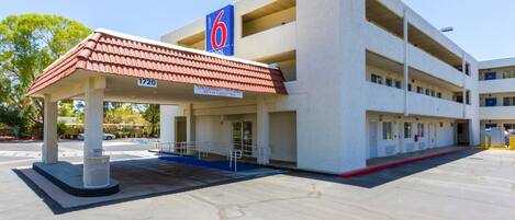 A motel with a two-story structure, a covered parking area, and a sign indicating the number of rooms.