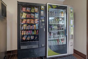 Una máquina expendedora con aperitivos y un dispensador de bebidas.