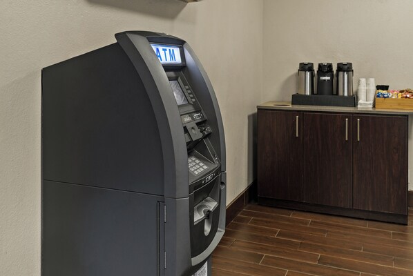 A self-service ATM machine with a digital display, a coffee machine, and a snack bar in a hotel room. - Red Roof Inn Spartanburg - I-85 (Spartanburg)