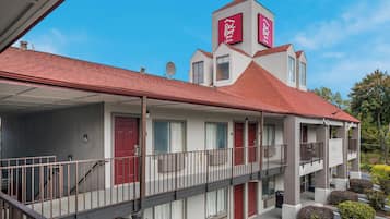 Un motel de dos pisos con techo rojo, varios balcones y un cartel que indica que es un Red Roof Inn & Suites.