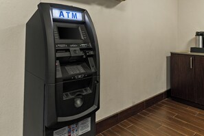 Un cajero automático con pantalla digital, lector de tarjetas y teclado numérico.