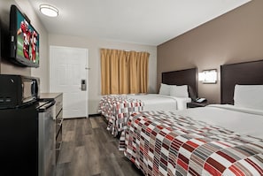 A hotel room with two beds, a TV, a desk, and a bathroom door.
