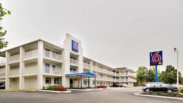 A motel with a '6' sign, multiple balconies, and a 'Welcome' entrance.