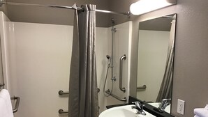 A bathroom with a shower, a sink, a mirror, and a towel rack. - Super 8 by Wyndham Woods Cross/Salt Lake City North (Woods Cross)