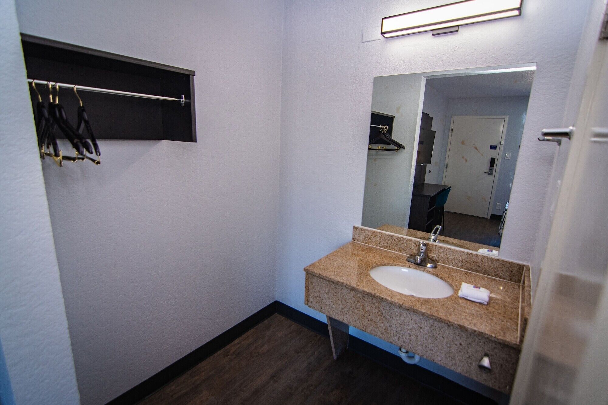 A small bathroom with a sink, mirror, and towel rack.