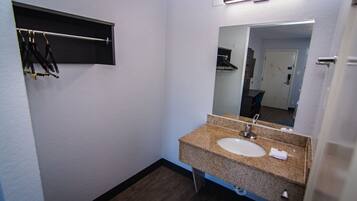 A small bathroom with a sink, mirror, and towel rack.