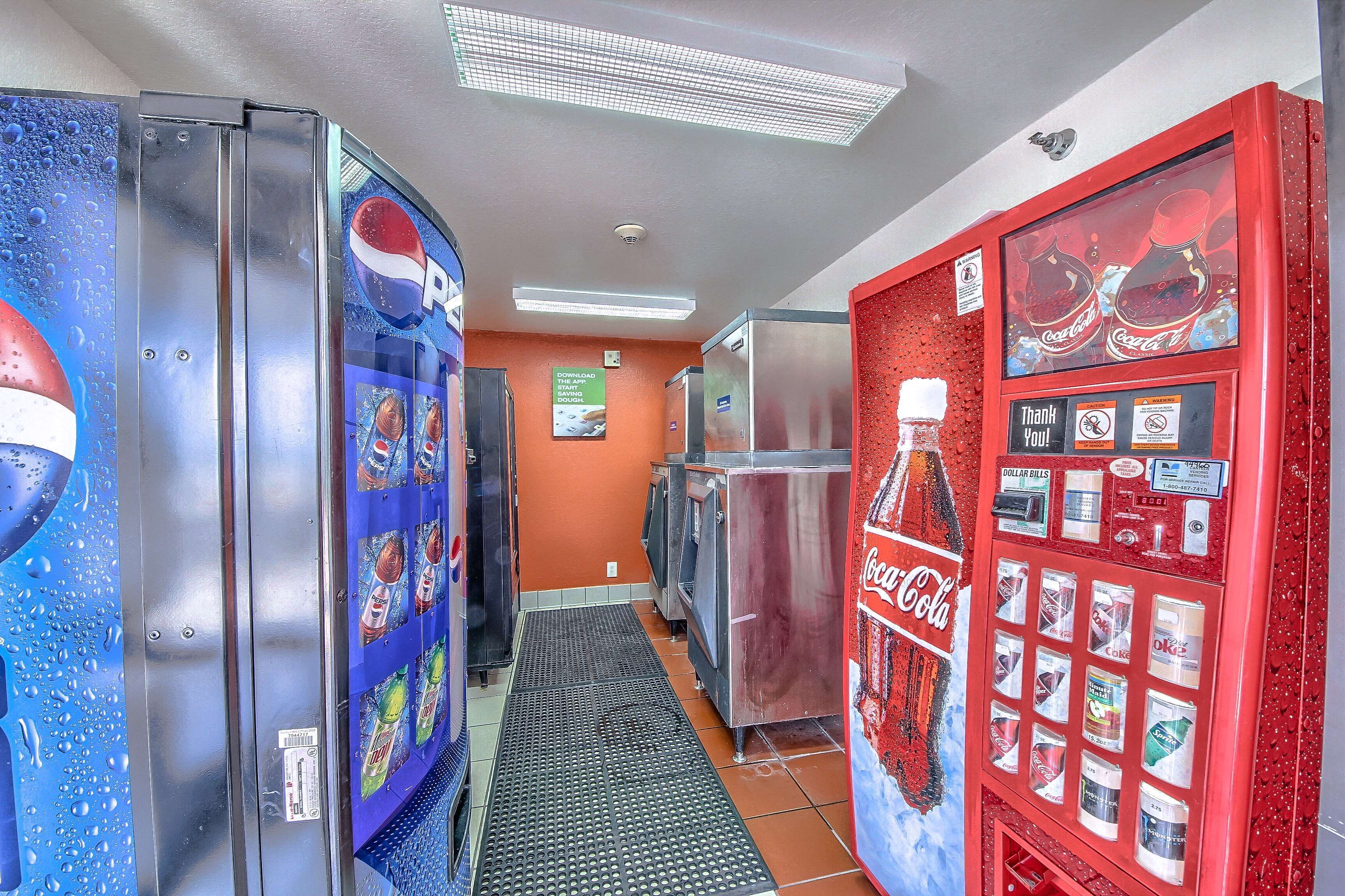 A corridor with vending machines and refrigerators, featuring Pepsi and Coca-Cola branding.