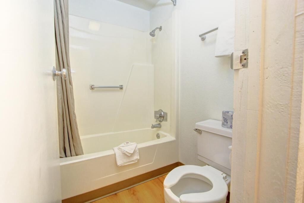 A bathroom with a bathtub, toilet, and a shower area.