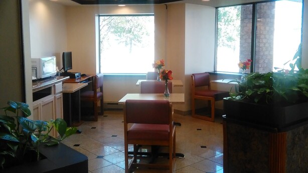 A restaurant with a TV, seating, and a window. - Americas Best Value Inn Horseheads (Horseheads)