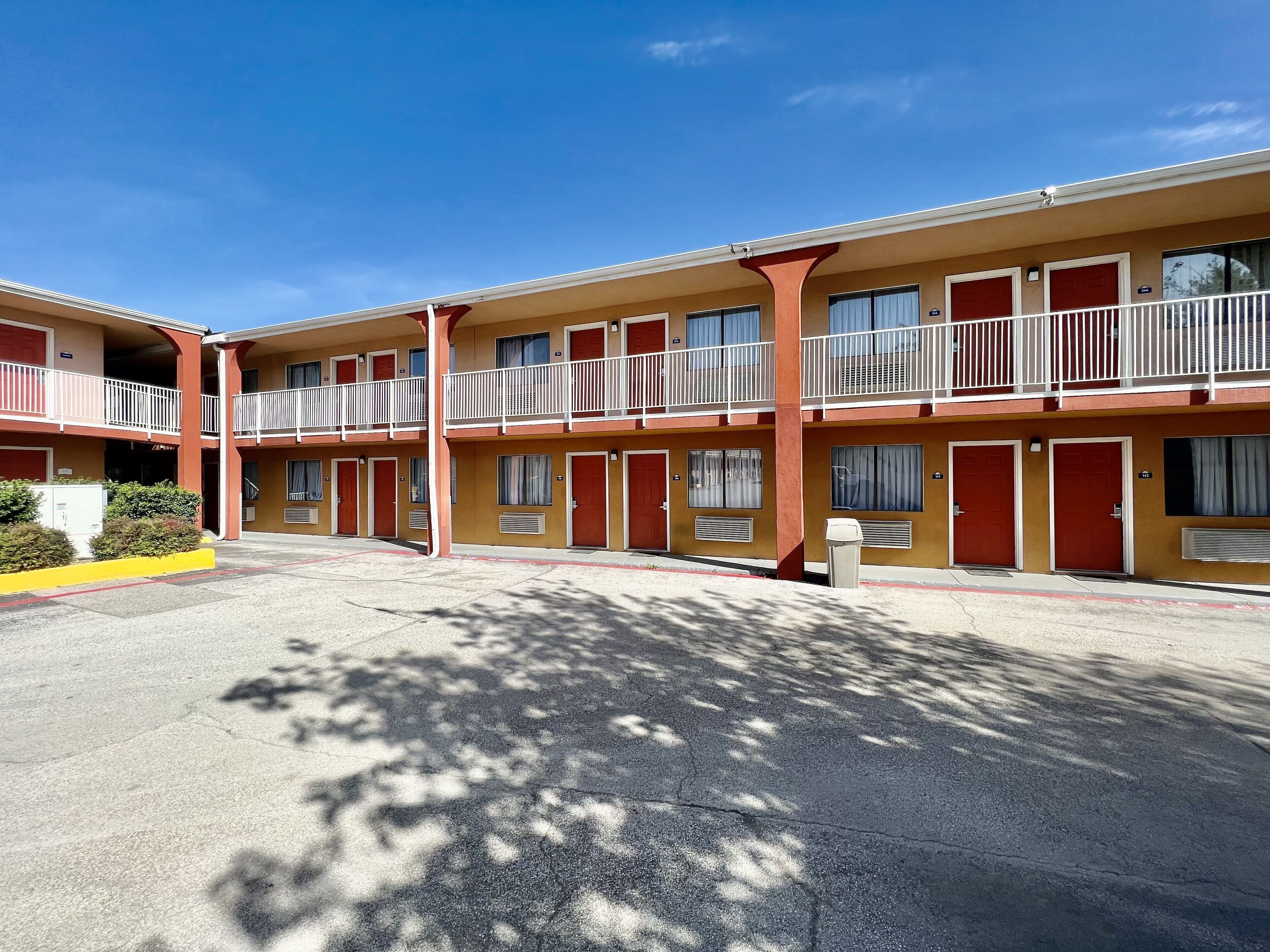 A motel with two-story buildings, each with balconies and a central courtyard.