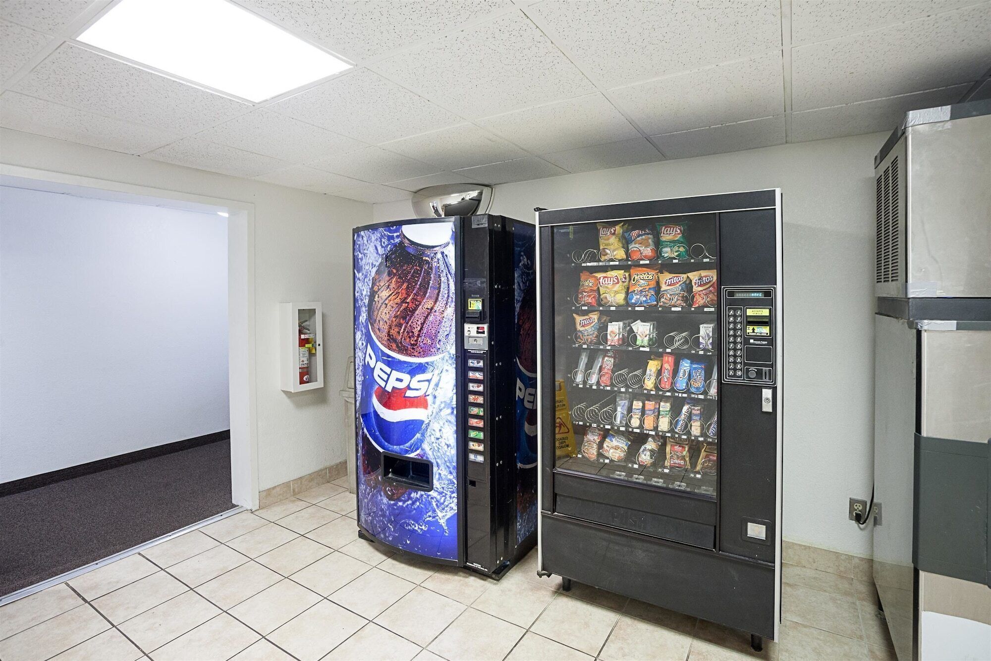 A vending machine with a Pepsi logo and a snack vending machine with various snacks.