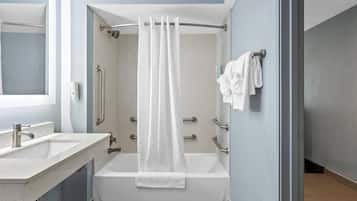 Un baño con bañera, ducha, lavabo y espejo.
