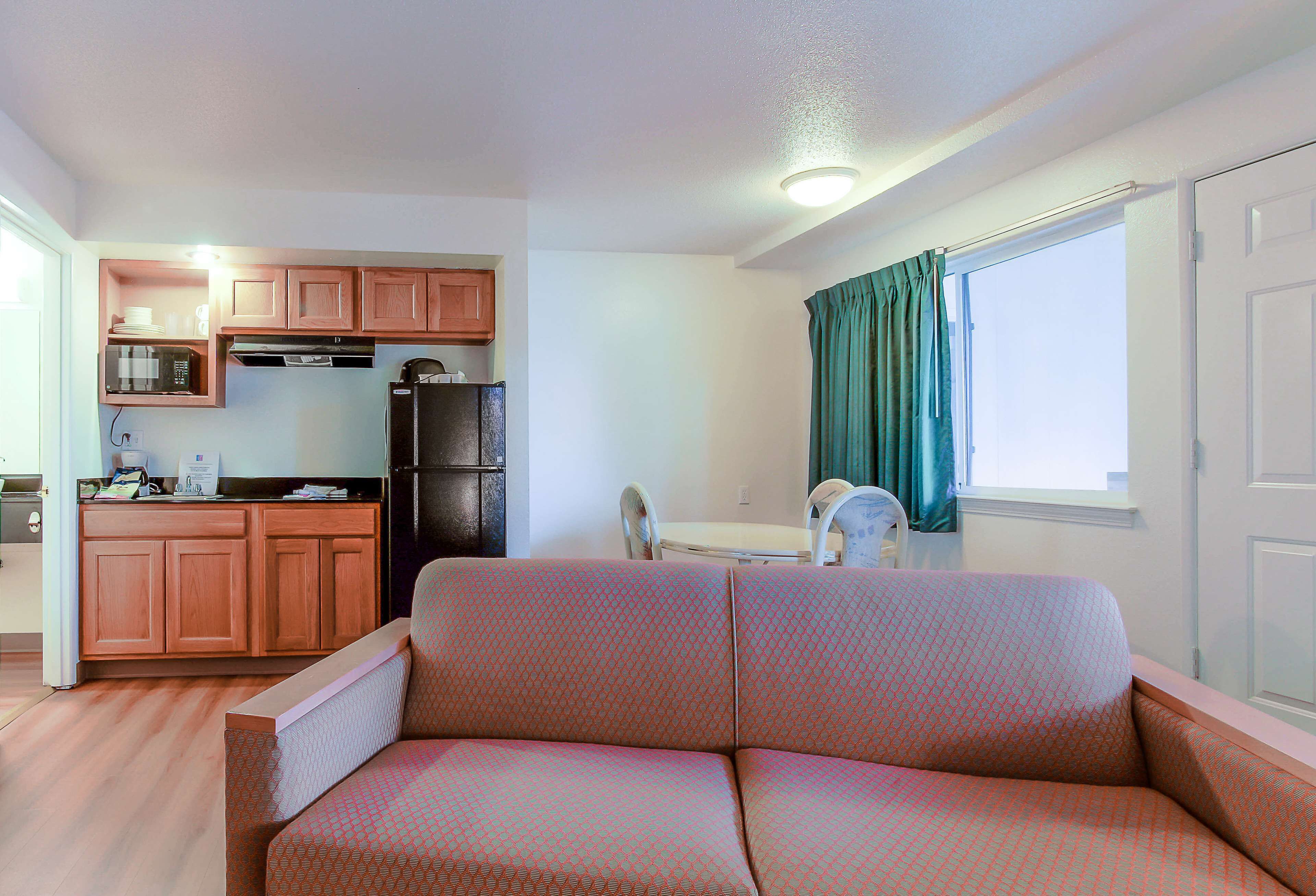 A compact living space with a kitchenette, a sofa, and a dining area.