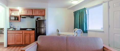 A compact living space with a kitchenette, a sofa, and a dining area.