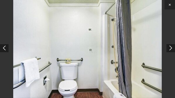 A small, compact bathroom with a toilet, a shower, and a grab bar. - Rodeway Inn Washington PA (Washington)
