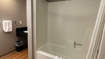 A modern bathroom with a glass-enclosed shower, a white bathtub, and a black sink.