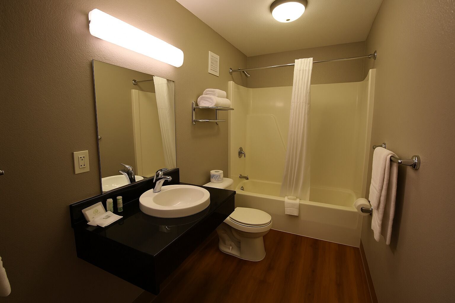 Un baño con lavabo, espejo, inodoro y ducha.