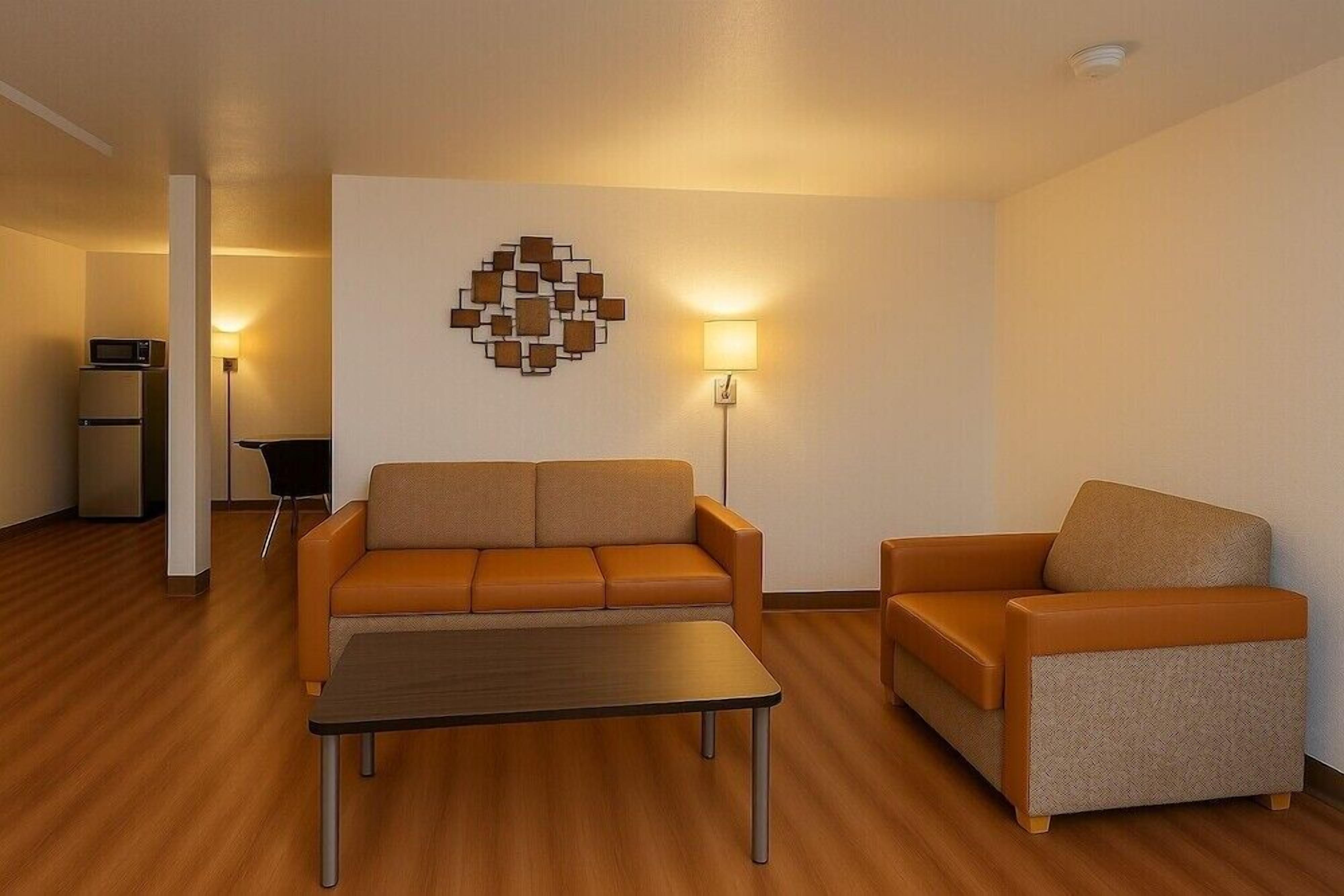 A modern living room with a sofa, armchair, and a coffee table.