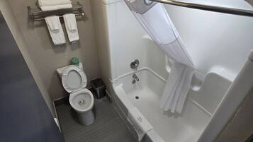 Un baño con inodoro, bañera y zona de ducha.