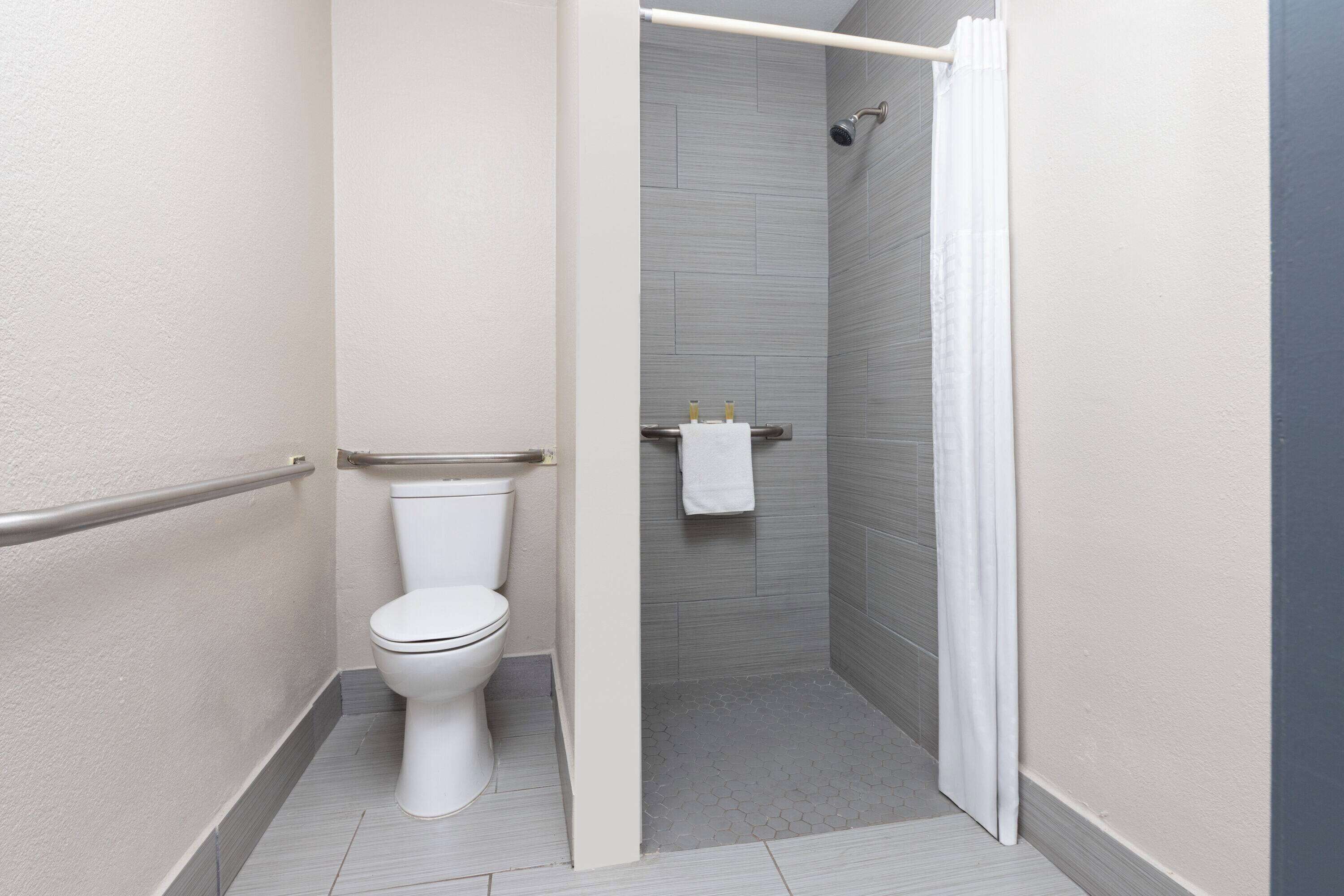 Un baño moderno con inodoro, ducha y toallero.