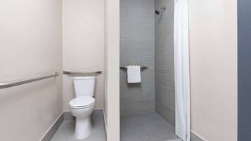 Un baño moderno con inodoro, ducha y toallero.