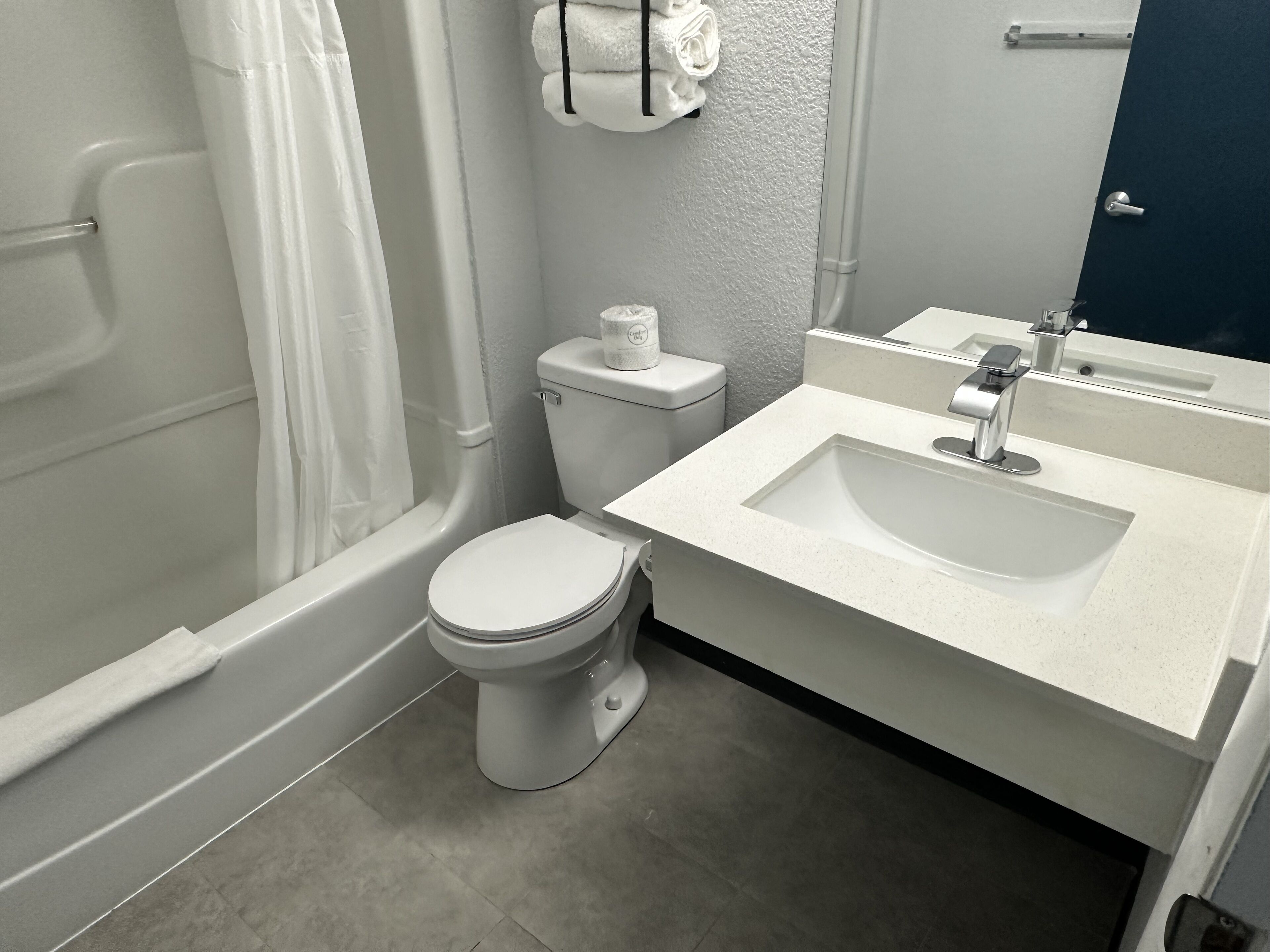 A bathroom with a toilet, sink, and shower.