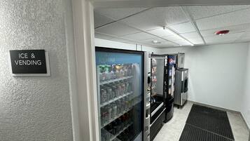 A vending area with an 'ICE & VENDING' sign, a refrigerator stocked with beverages, and a Pepsi vending machine.