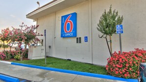 A motel with a prominent '6' sign indicating the office location.