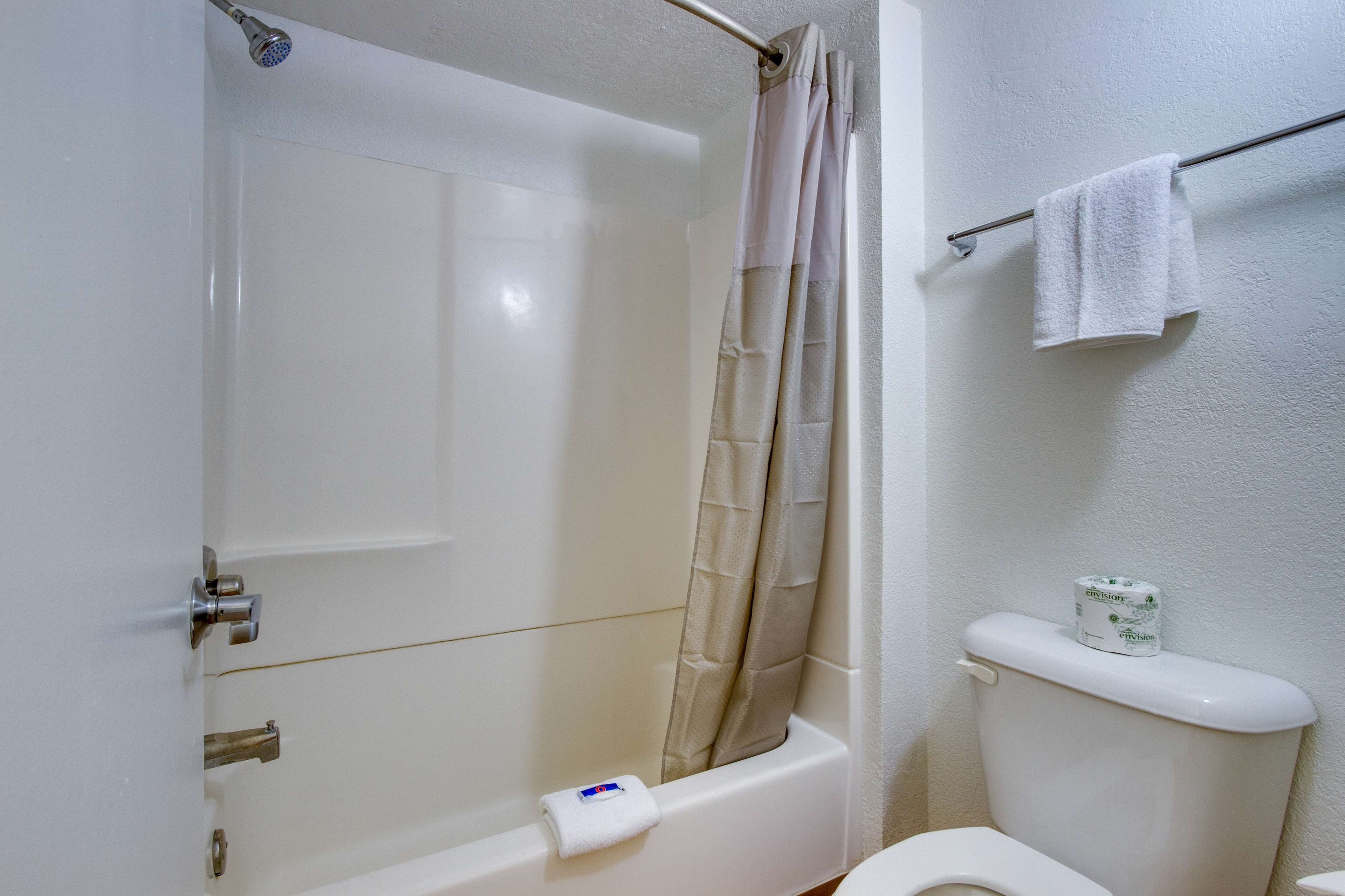 A bathroom with a bathtub, toilet, and a shower curtain.