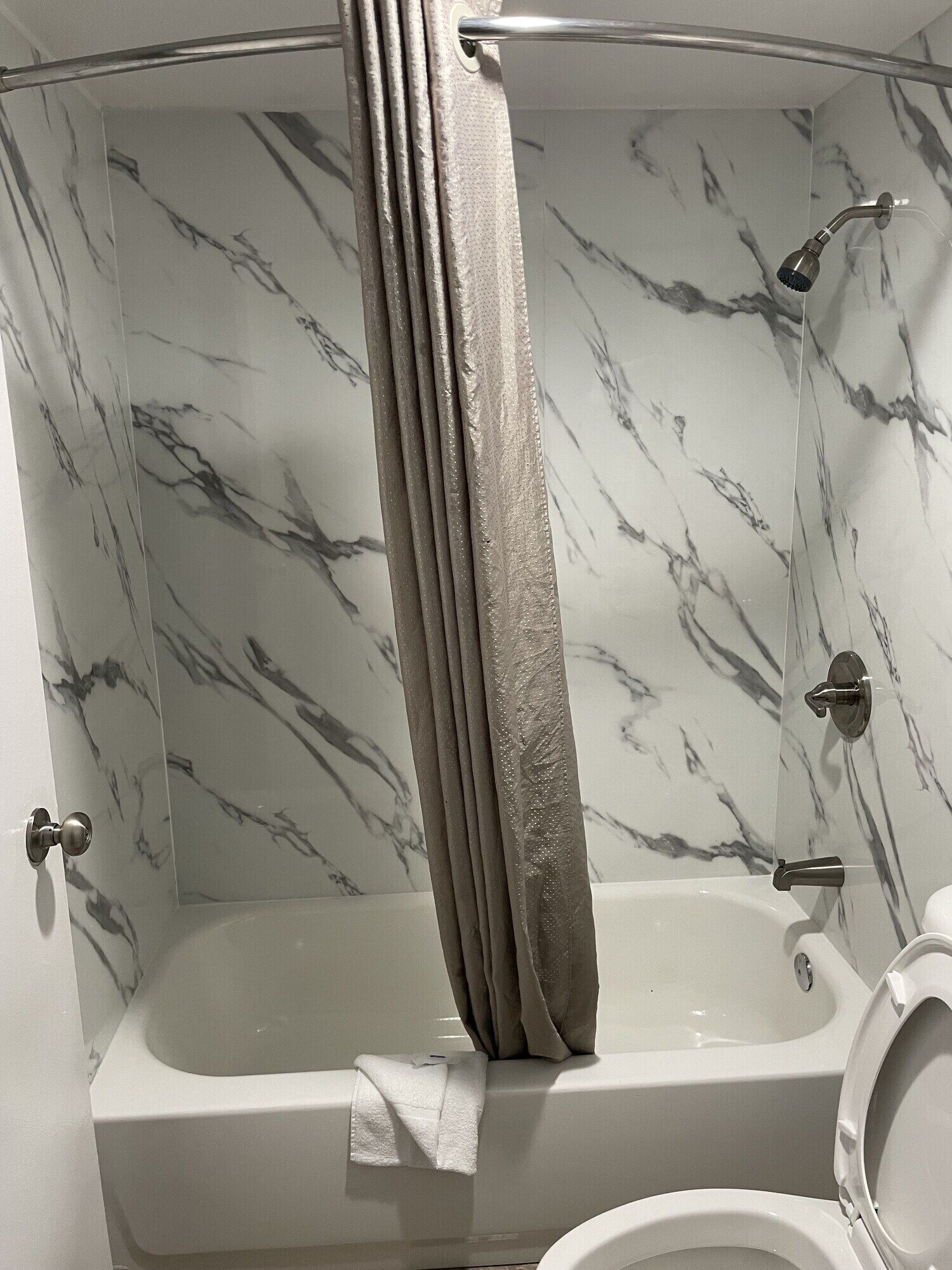 Un baño con bañera, ducha e inodoro.